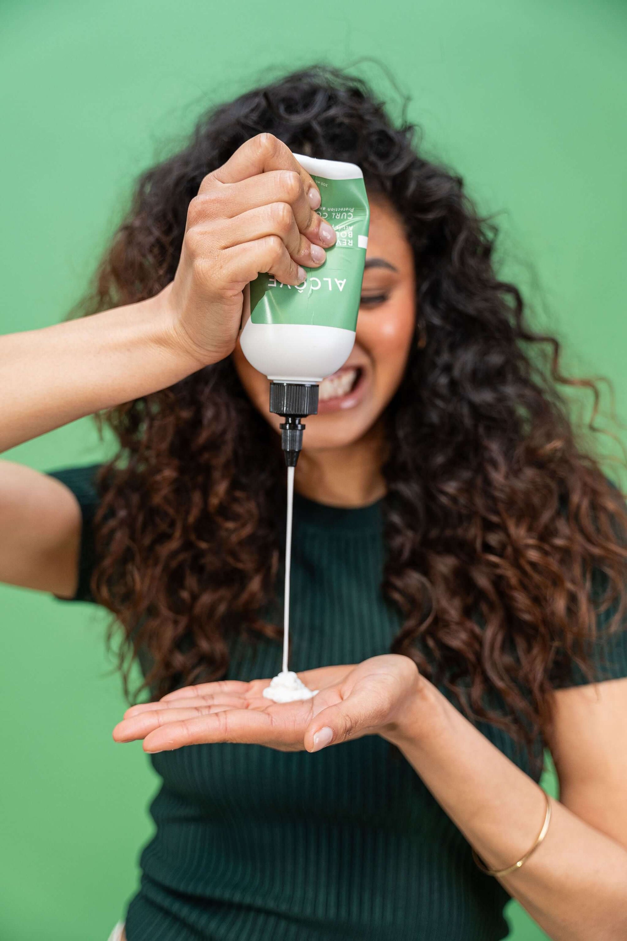 Person showing how to use the Alcôve Hair Curl Conditioner in the palm of her hand