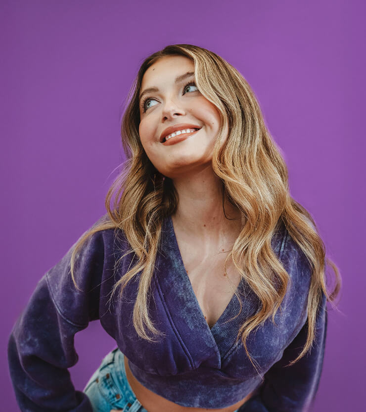 Woman wearing a purple top against a purple background